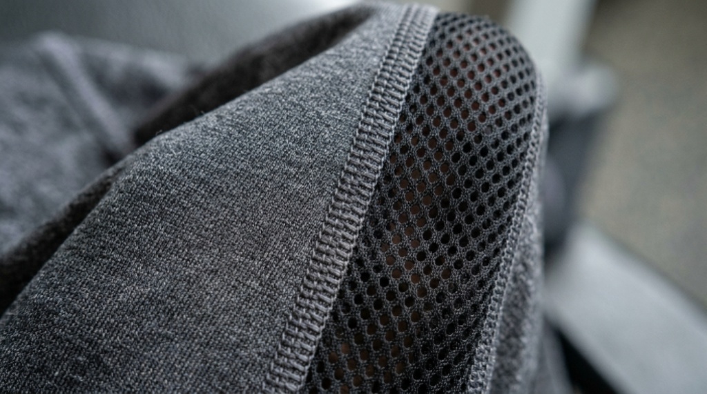 Close-up of breathable workout clothes fabric showing mesh ventilation panels and flatlock seam construction
